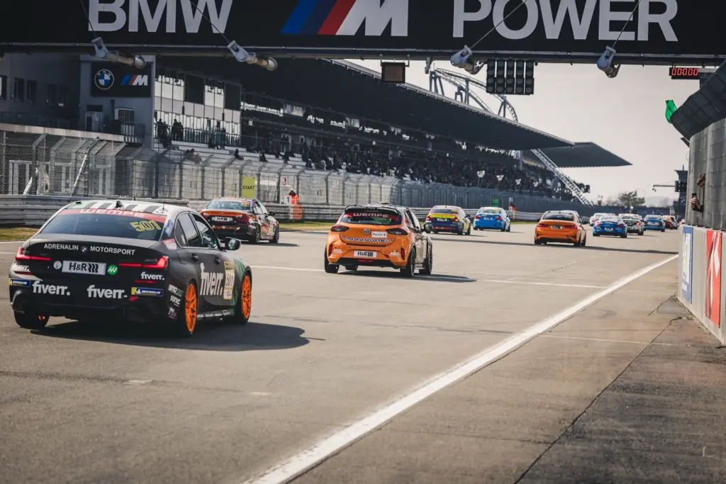 NLS Rennstart 2026 am Nürburgring mit mehreren Rennfahrzeugen auf der Start- und Zielgeraden.